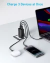 Anker wall charger charging three devices at once, including a laptop, a smartphone, and wireless earbuds