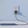 Anker wall charger plugged into an outlet, charging a smartphone placed on a table