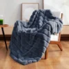 A plush grey Cozy Bliss Faux Fur Throw Blanket draped over a stylish armchair, showing off its ultra-soft, reversible texture in a cozy living room setting.